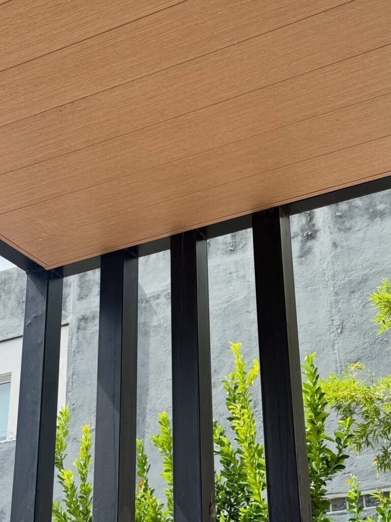 Galería con cielorraso de madera y carpinterías negras